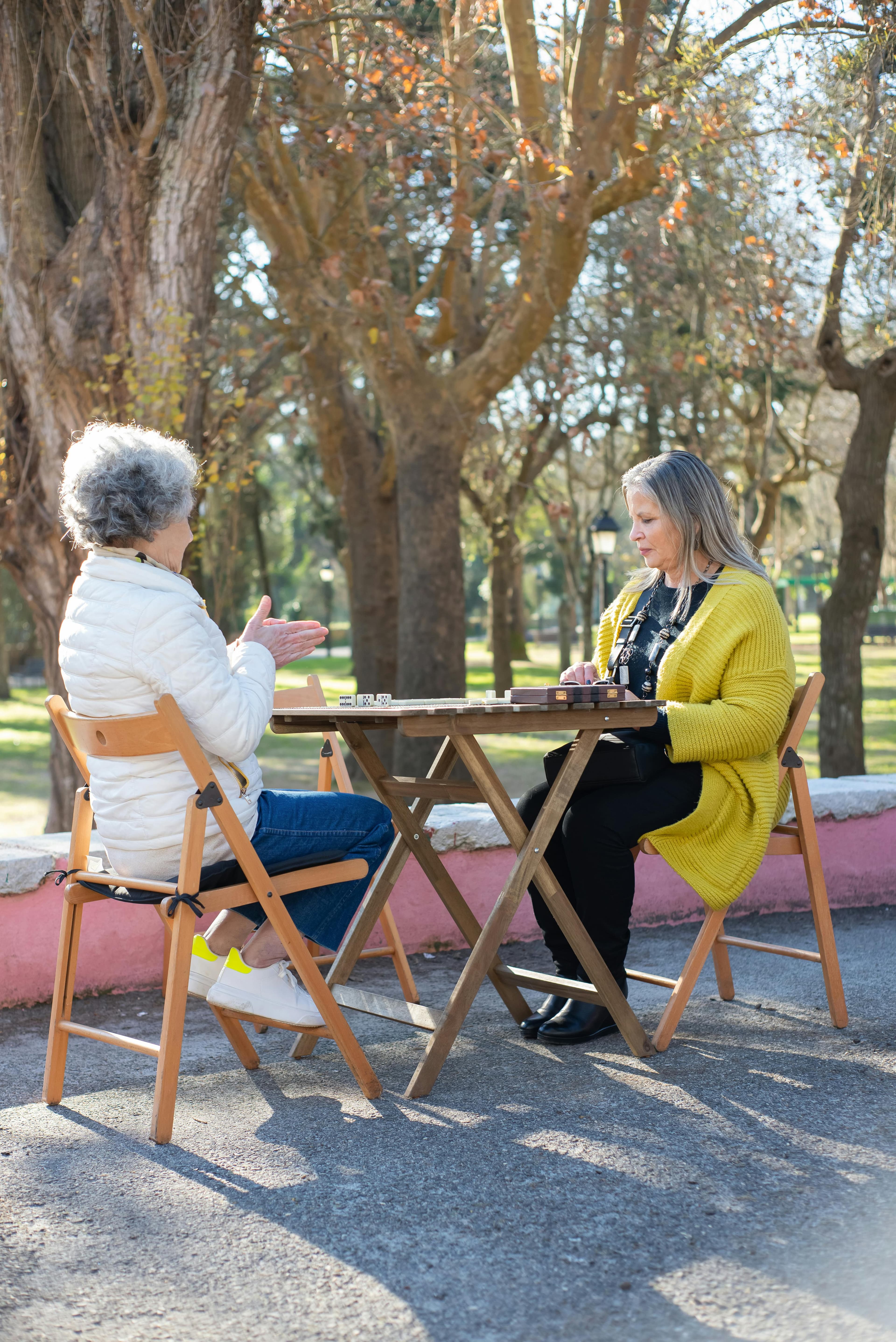 Dos personas mayores conversando sentadas en un parque