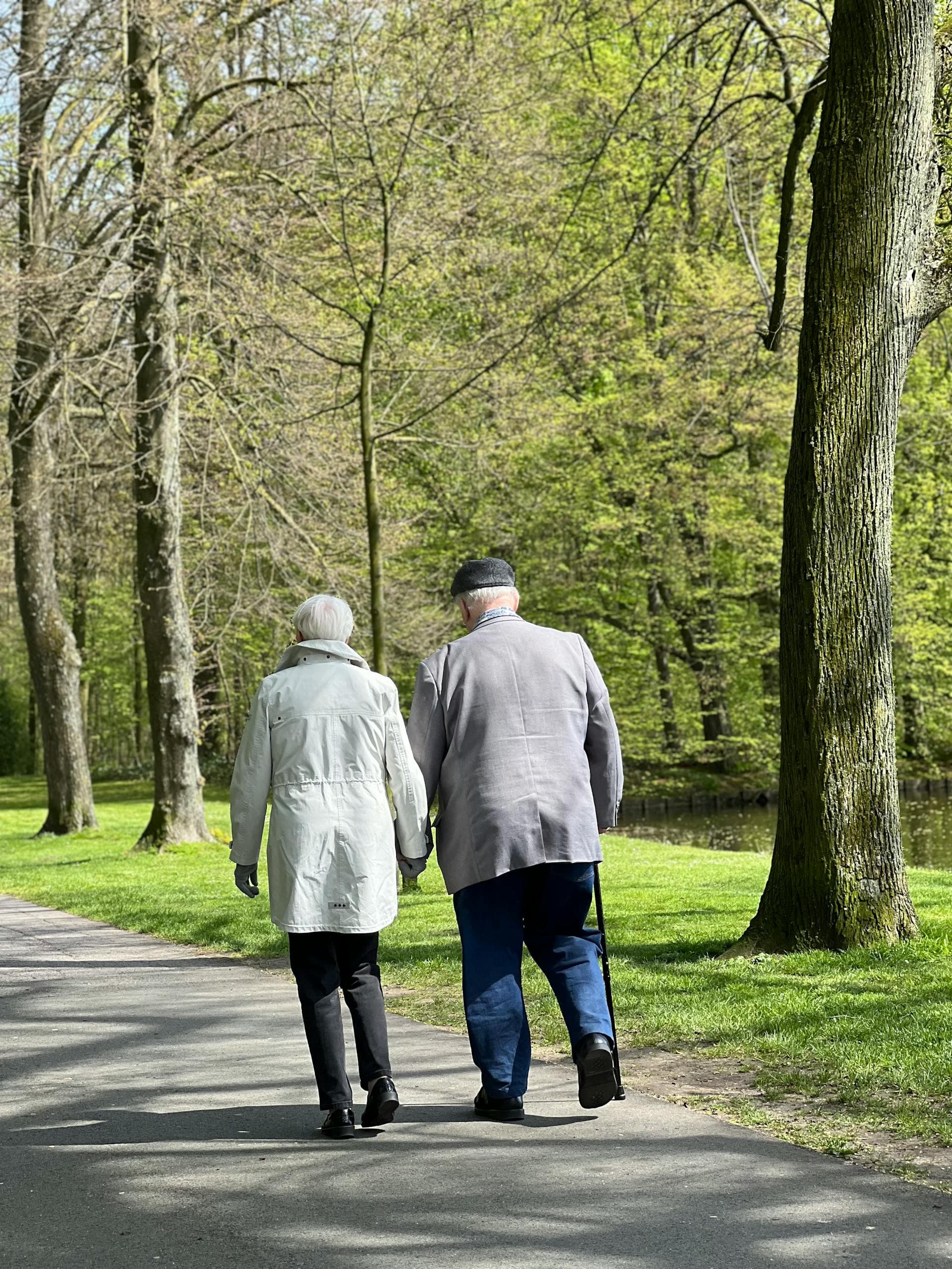 Dos personas mayores caminando juntas en un parque