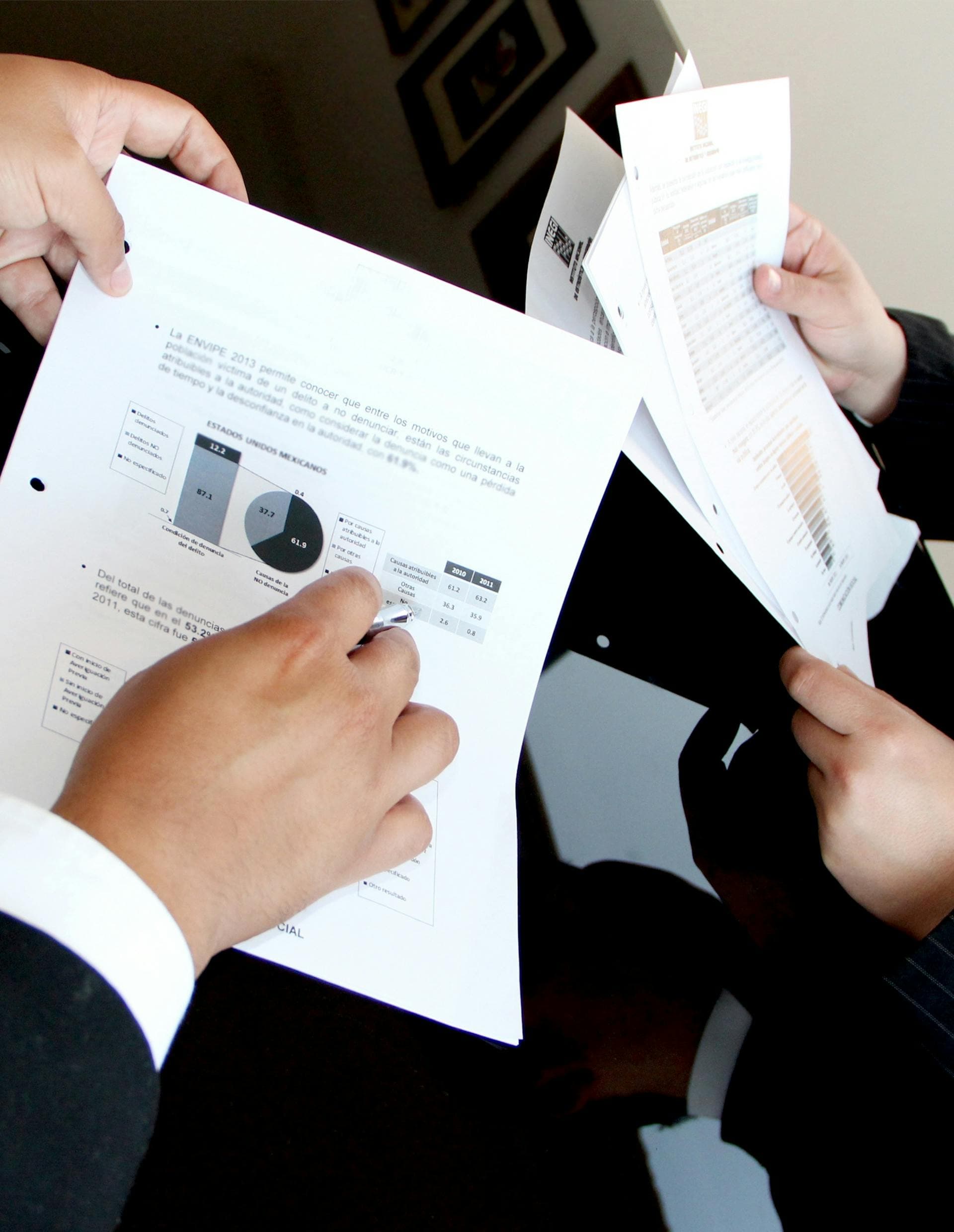 Personas revisando documentos sobre una mesa